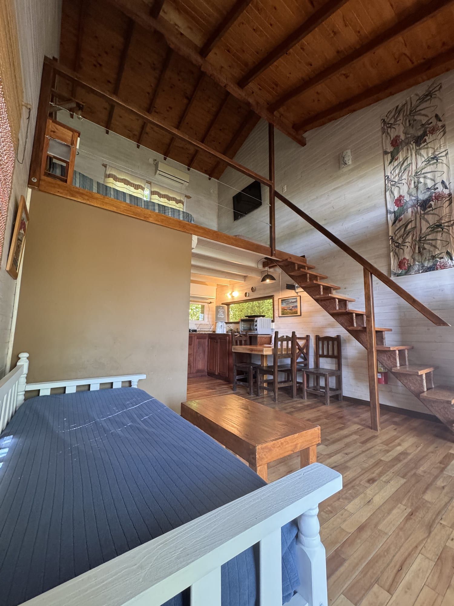 Interior de Arrebol: doble altura con entrepiso y escalera.