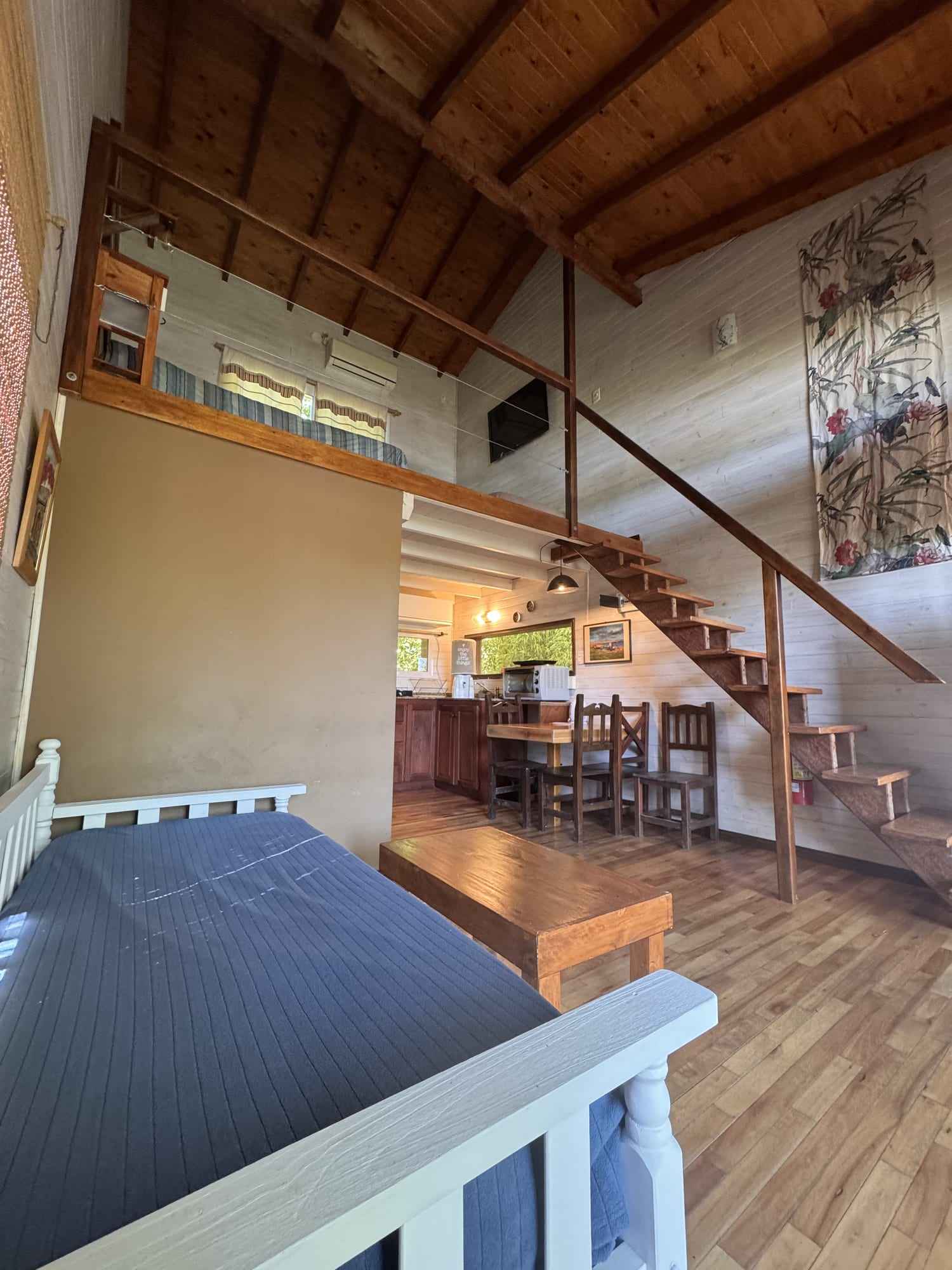 Interior de Arrebol: doble altura con entrepiso y escalera.