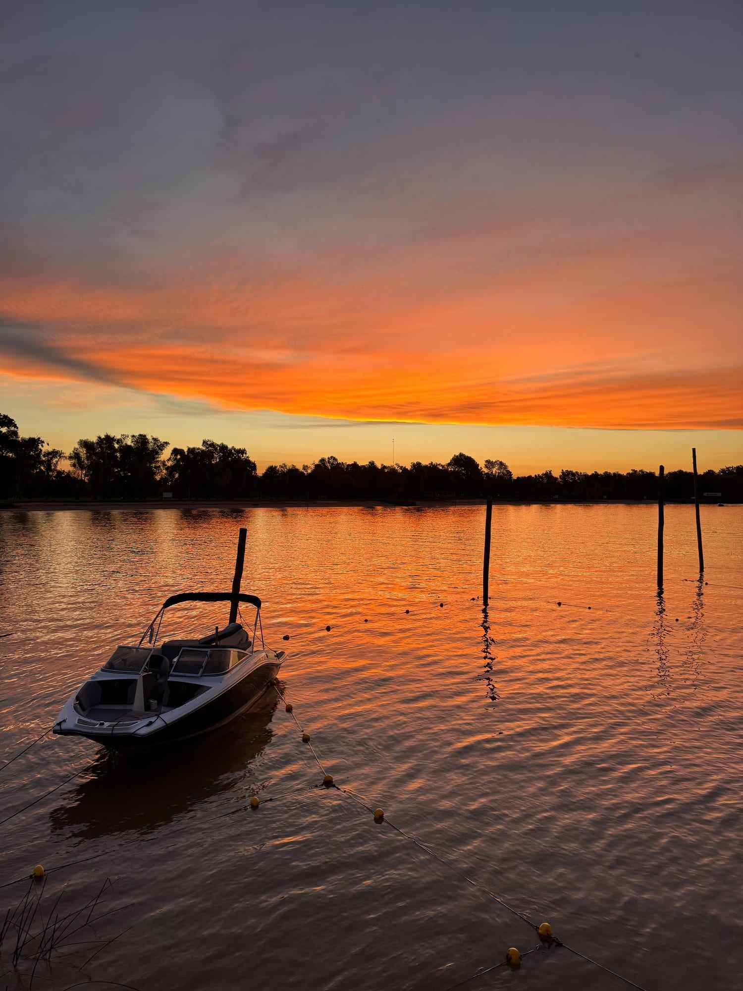 Atardecer en el río con una lancha amarrada.