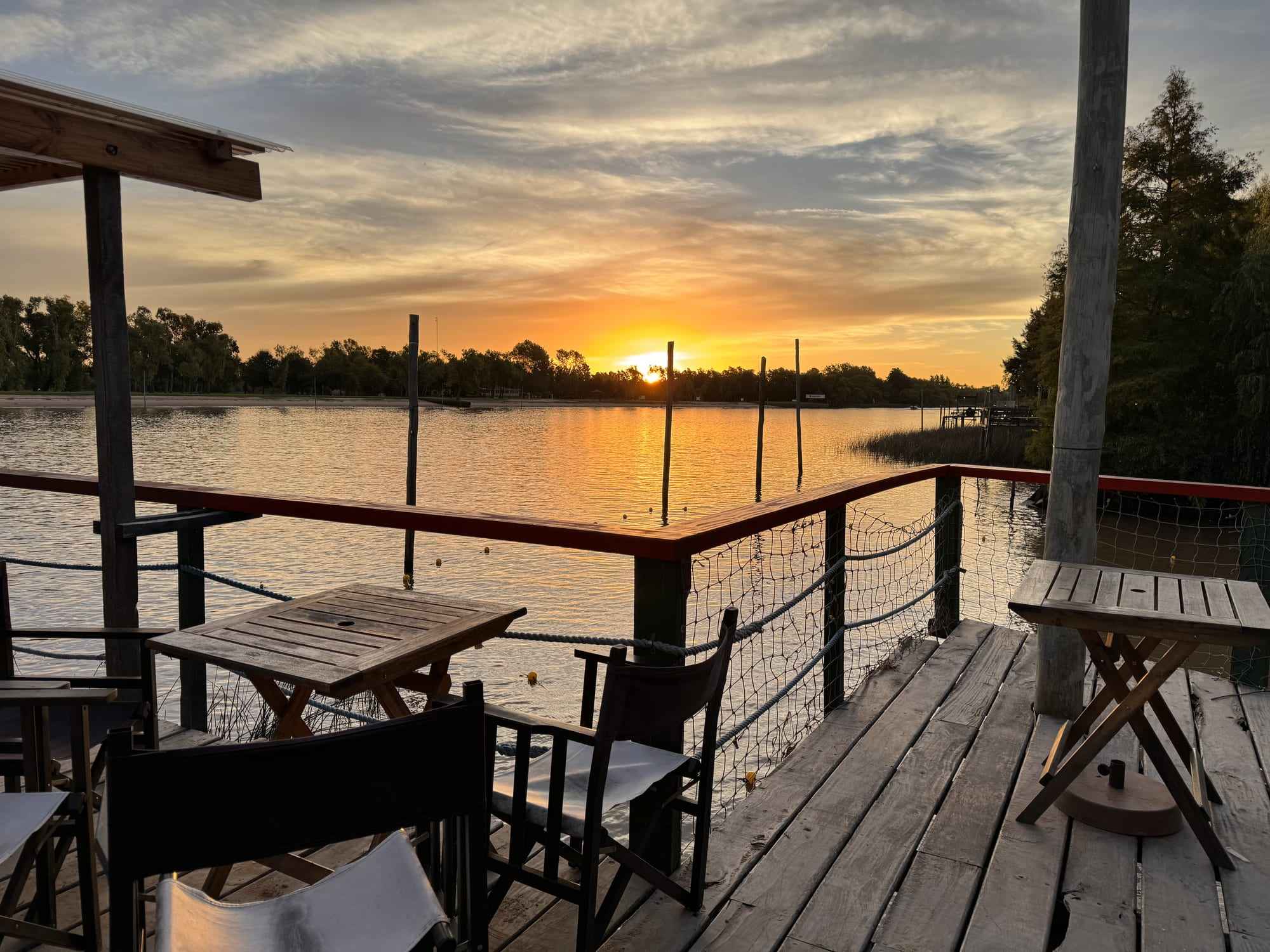 Deck de madera sobre el río al atardecer.