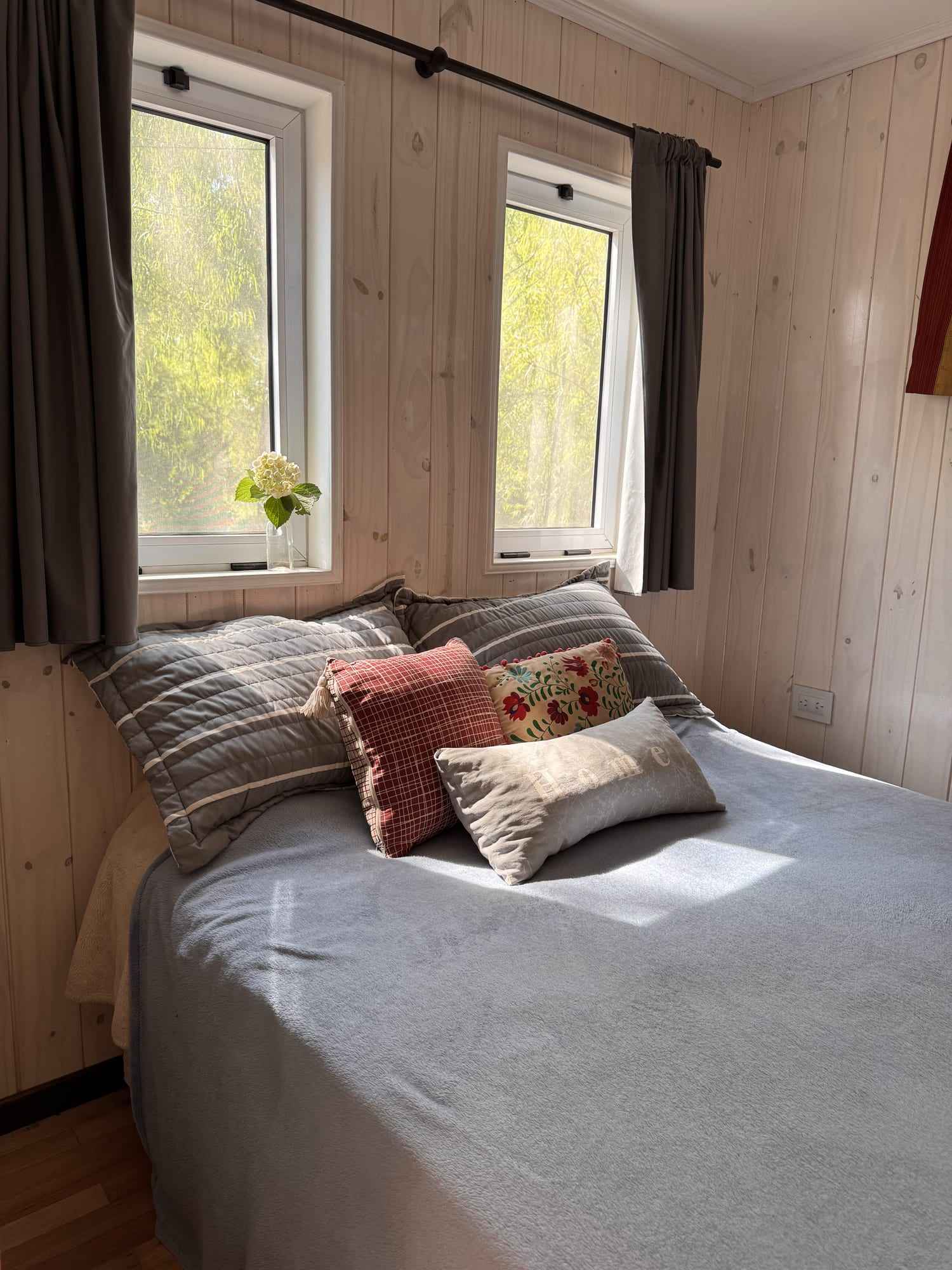 La cama matrimonial junto a la ventana.