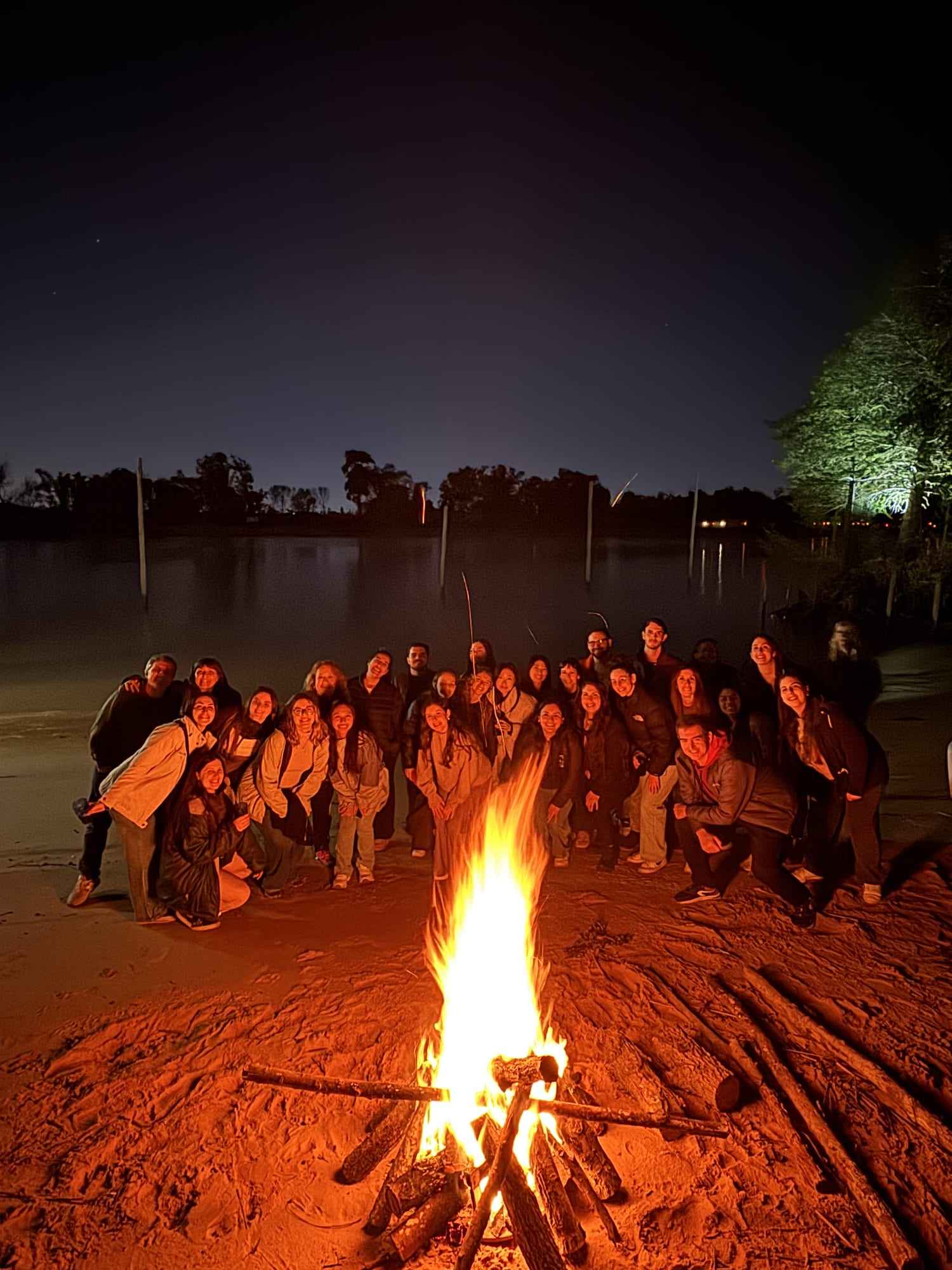Un grupo alrededor del fogón en la playa, de noche.