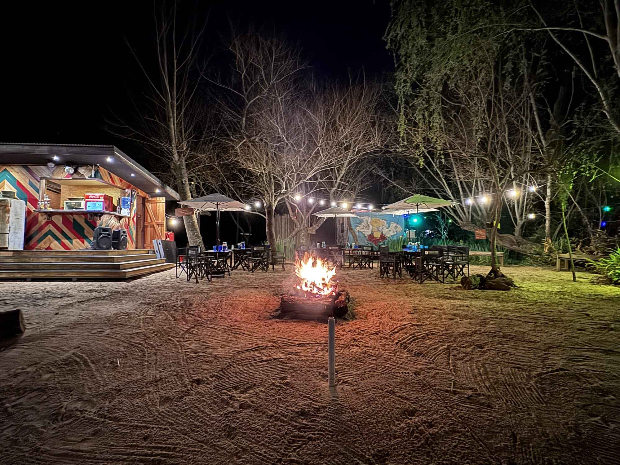 El predio de noche con el fogón encendido.