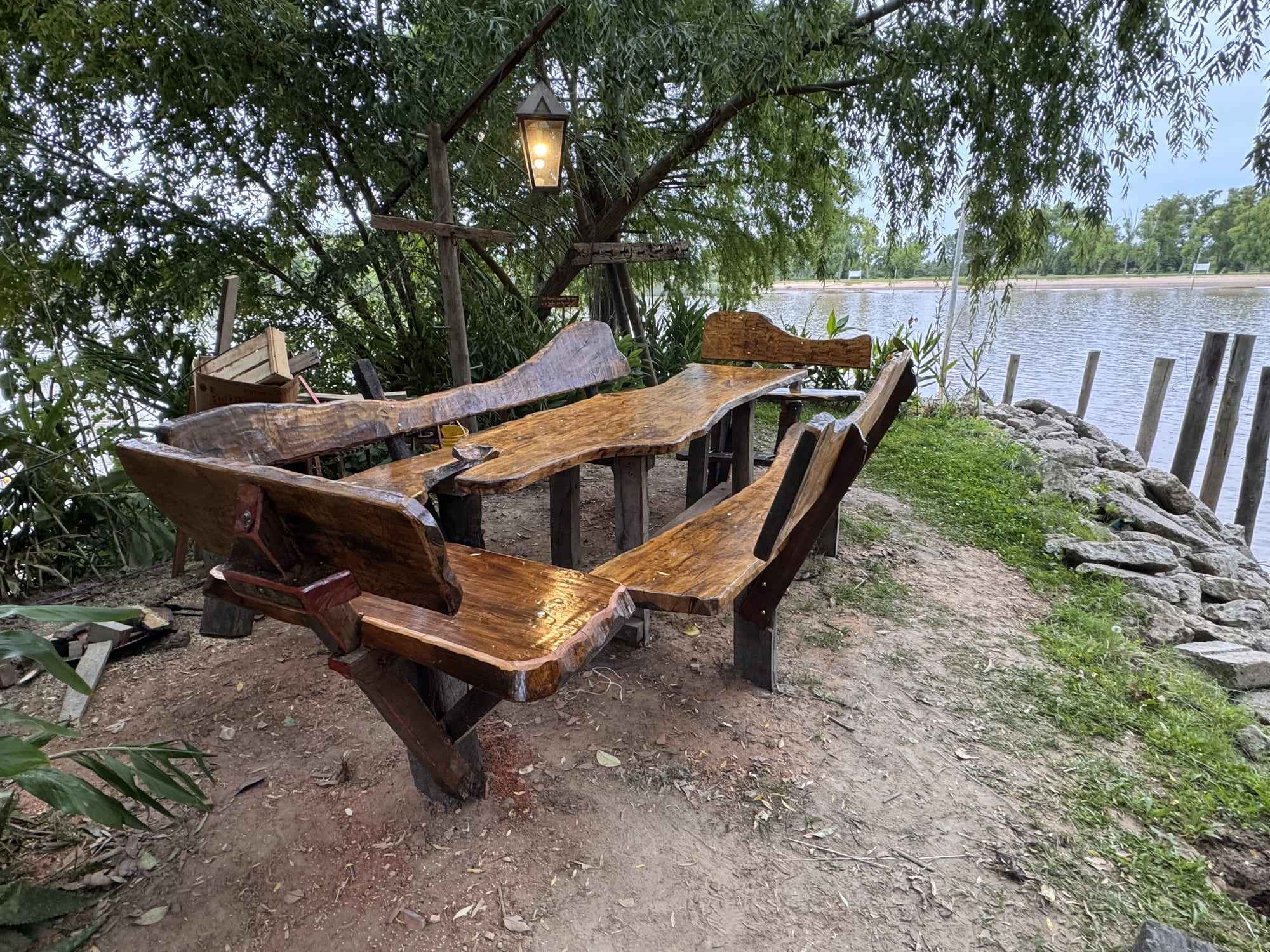 Mesas y bancos de madera a la orilla del río.