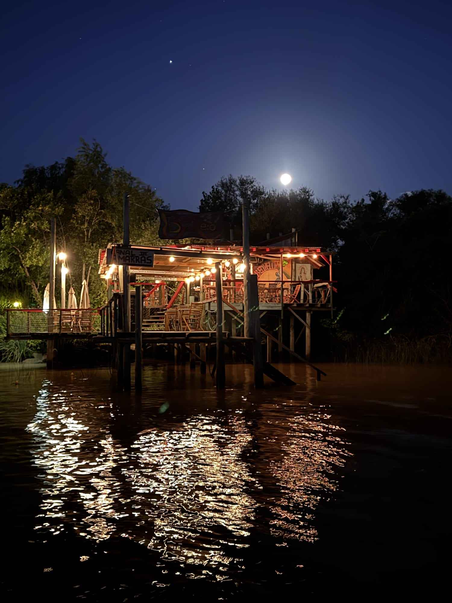 El parador iluminado de noche, reflejado en el río.
